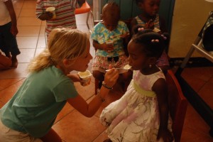 Reese feeds yogurt to one little ange.