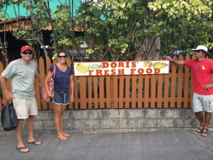 Grown-ups posing in front of a tiny supermarket as if they were at Disney.